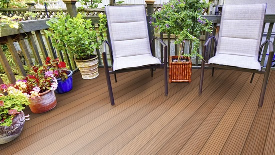 Terrassendiele TD-PrimeKDg-Ba-25-145 mm, braun, für Außenbereich geeignet, verlegt auf Terrasse mit Pflanzen und Stühlen
