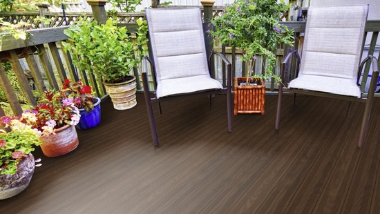 TD-System-Frank-21-130- Terrassendiele, dunkelbraun, Holzoptik, für Außenbereich geeignet, verlegt auf Terrasse mit Pflanzen